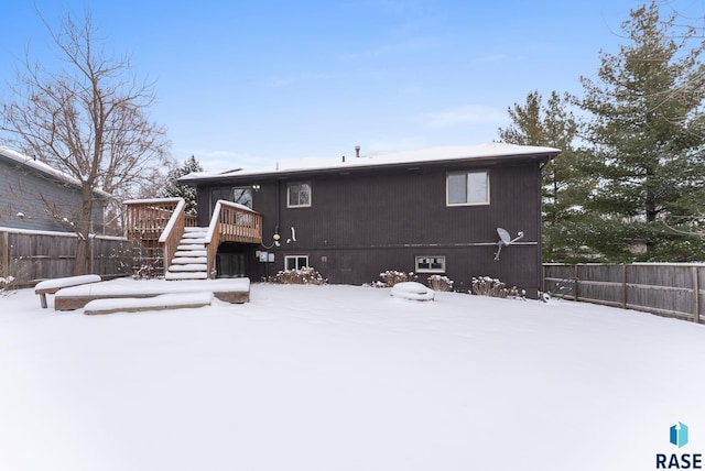 snow covered house with a deck