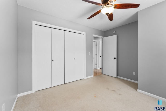 unfurnished bedroom with light carpet, ceiling fan, and a closet