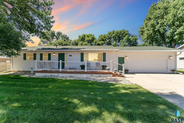 ranch-style home with a garage and a lawn