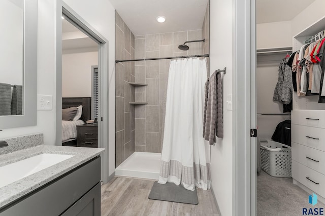 bathroom featuring walk in shower, vanity, and hardwood / wood-style flooring