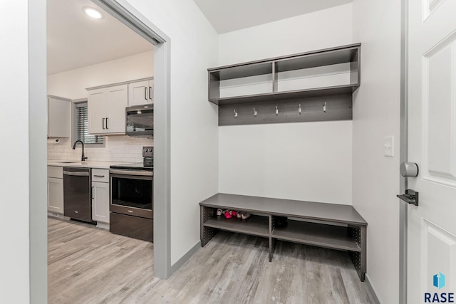 mudroom with sink and light hardwood / wood-style floors