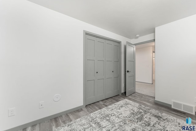 unfurnished bedroom with light hardwood / wood-style floors and a closet