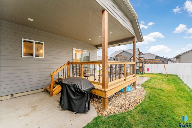 wooden terrace featuring a grill, a lawn, and a playground