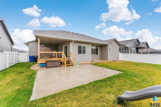 rear view of property with a deck, a patio, and a lawn