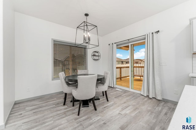 dining area with an inviting chandelier and light hardwood / wood-style floors