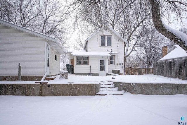 view of snow covered back of property