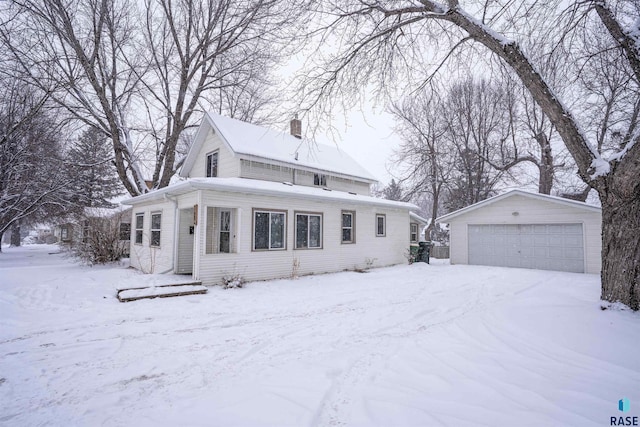 view of front of house featuring a garage and an outbuilding