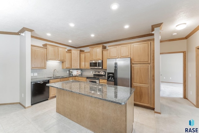 kitchen with a sink, a kitchen island, appliances with stainless steel finishes, dark stone counters, and crown molding