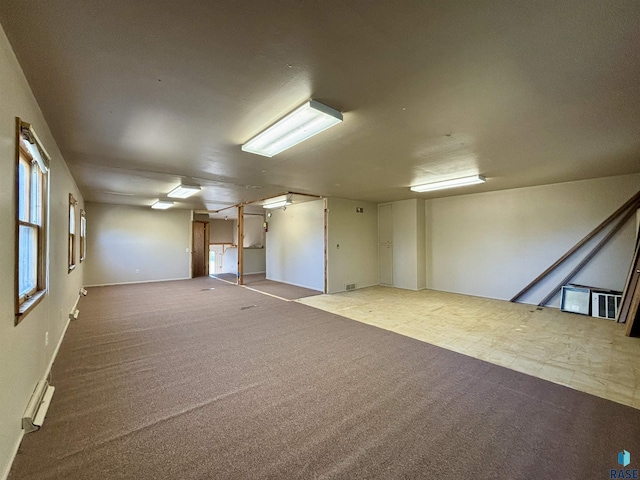 unfurnished room with carpet floors and baseboard heating