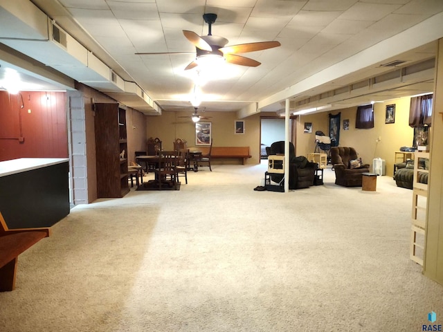 basement featuring carpet flooring and ceiling fan