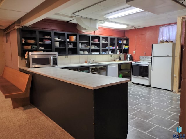 kitchen featuring sink, tile patterned floors, white appliances, and kitchen peninsula