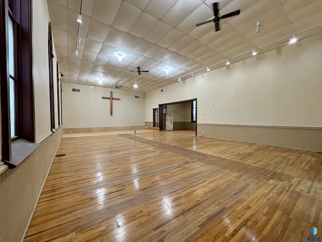 unfurnished room featuring ceiling fan, track lighting, and light wood-type flooring