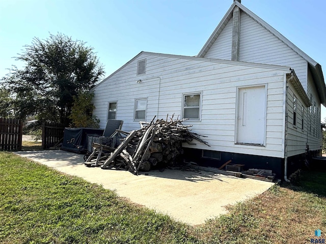 rear view of house with a lawn and a patio