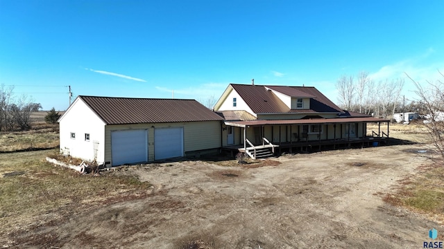 rear view of property featuring a garage and covered porch