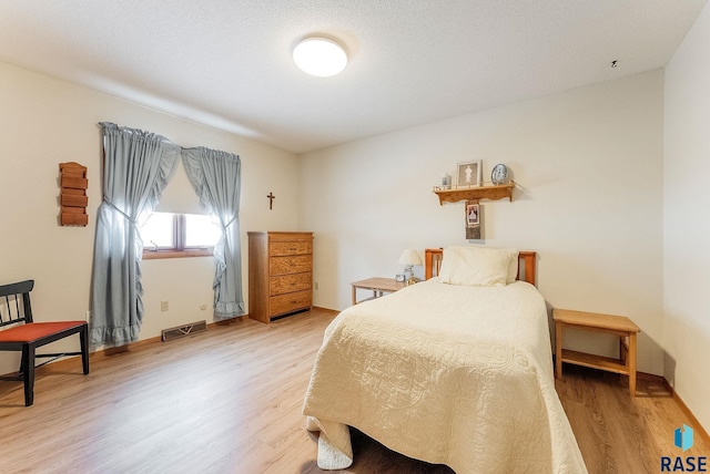 bedroom with hardwood / wood-style flooring and a textured ceiling