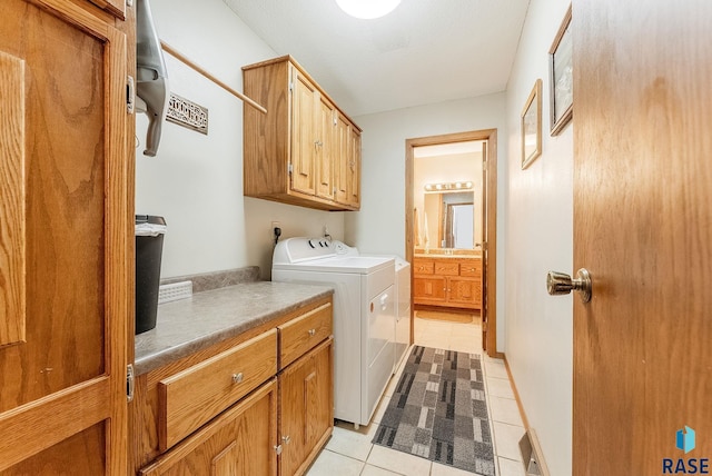 washroom featuring cabinets, washer and dryer, and light tile patterned floors