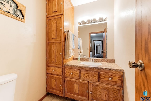 bathroom featuring vanity, tile patterned floors, and toilet