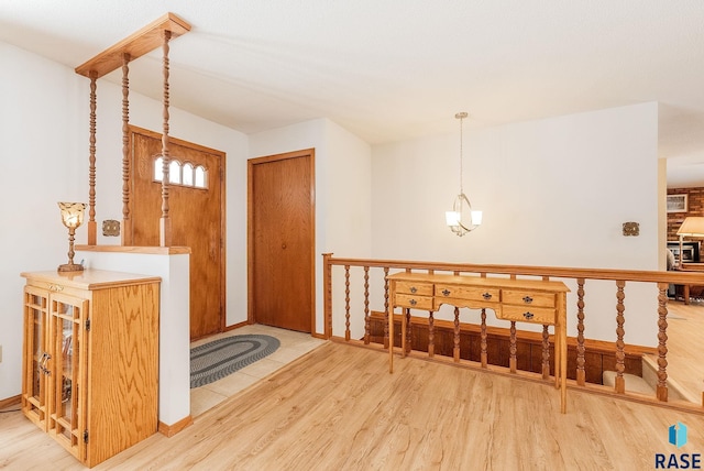 foyer with wood-type flooring and a notable chandelier