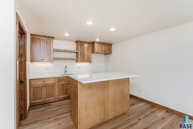 kitchen featuring sink, light hardwood / wood-style flooring, and a center island