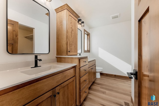 bathroom featuring hardwood / wood-style flooring, vanity, and toilet