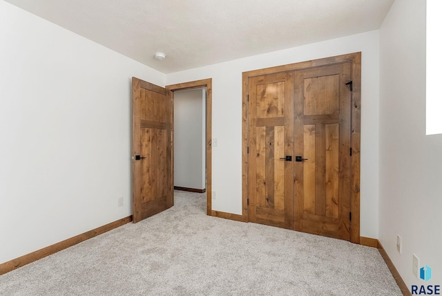 unfurnished bedroom featuring light colored carpet and a closet