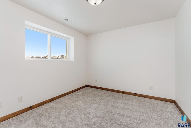 spare room featuring light carpet