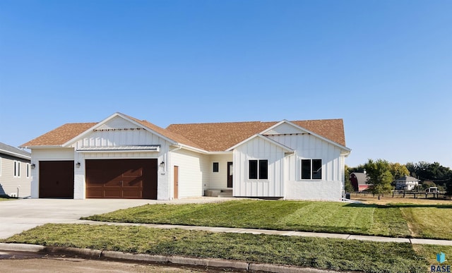 modern inspired farmhouse featuring a garage and a front yard