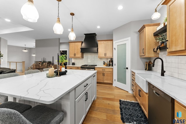 kitchen featuring sink, stainless steel gas range, a breakfast bar, dishwasher, and custom exhaust hood