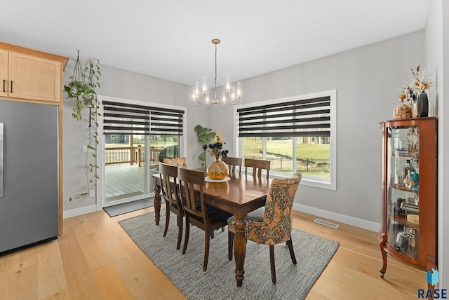 dining space with a chandelier and light wood-type flooring