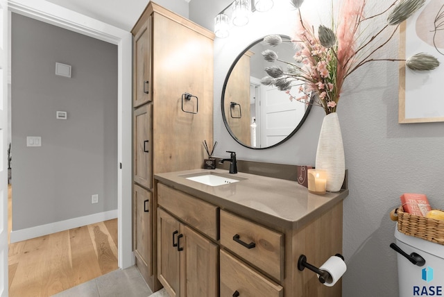 bathroom with wood-type flooring, vanity, and toilet