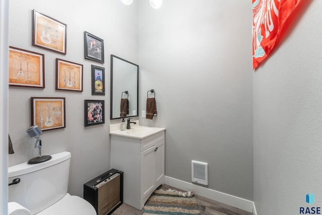 bathroom featuring vanity, wood-type flooring, and toilet