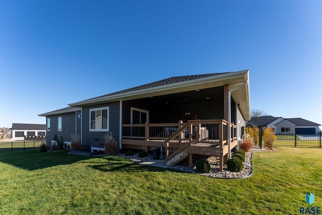 back of house featuring a wooden deck and a yard