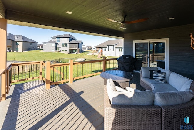 wooden deck with a lawn, ceiling fan, a playground, area for grilling, and an outdoor hangout area