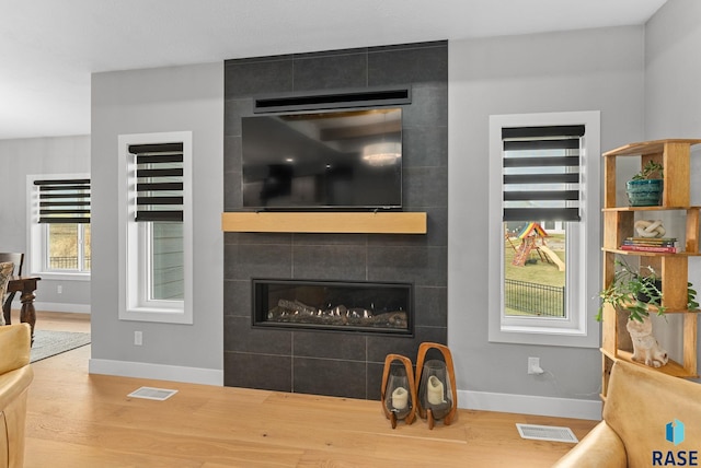 interior space featuring a tiled fireplace and wood-type flooring