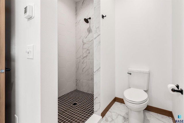 bathroom featuring tiled shower and toilet