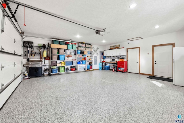 garage with a garage door opener and white fridge with ice dispenser