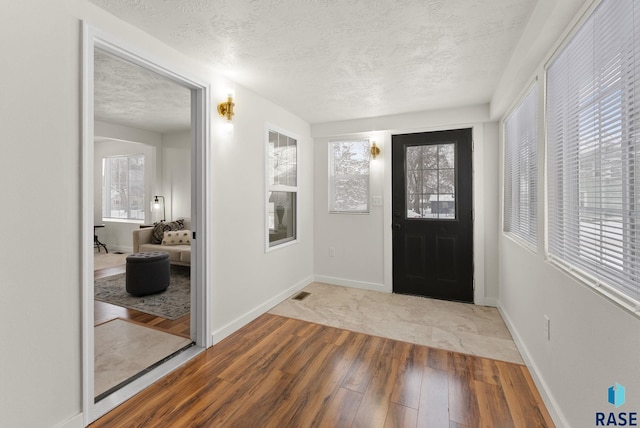 foyer with light hardwood / wood-style floors and a textured ceiling