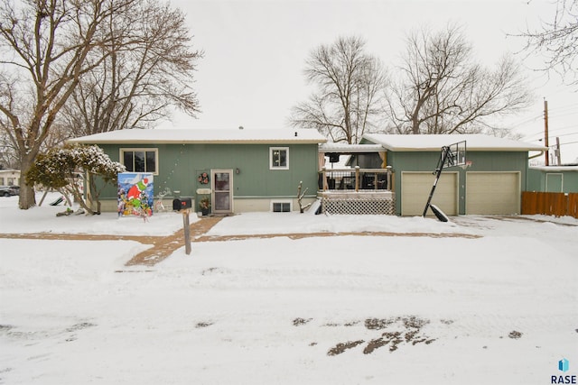 snow covered property featuring an attached garage