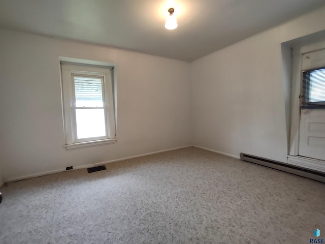 empty room with a baseboard heating unit and a healthy amount of sunlight