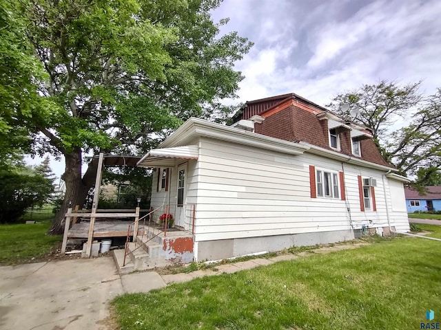 view of side of home with a lawn