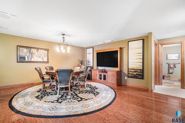 dining area featuring hardwood / wood-style floors and an inviting chandelier