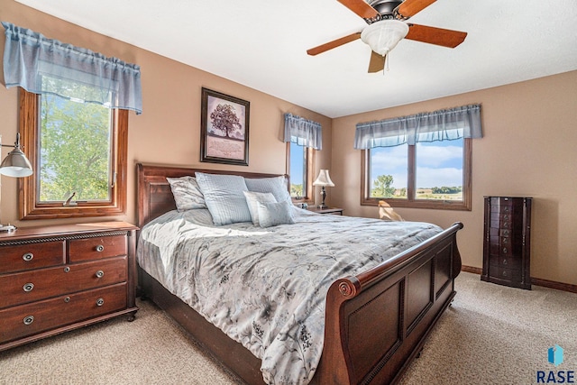 bedroom with multiple windows, light colored carpet, and ceiling fan