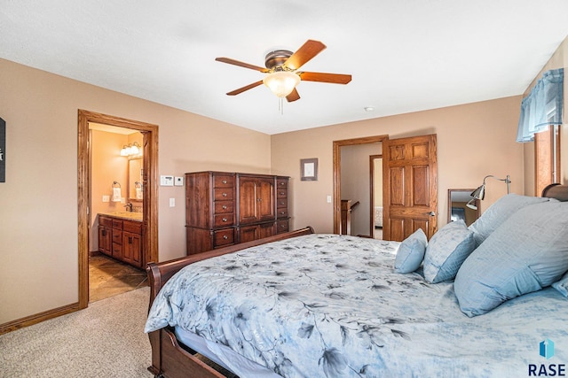 bedroom featuring ensuite bathroom, sink, light colored carpet, and ceiling fan