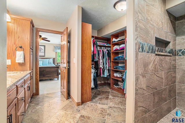 bathroom with vanity, a tile shower, and a textured ceiling