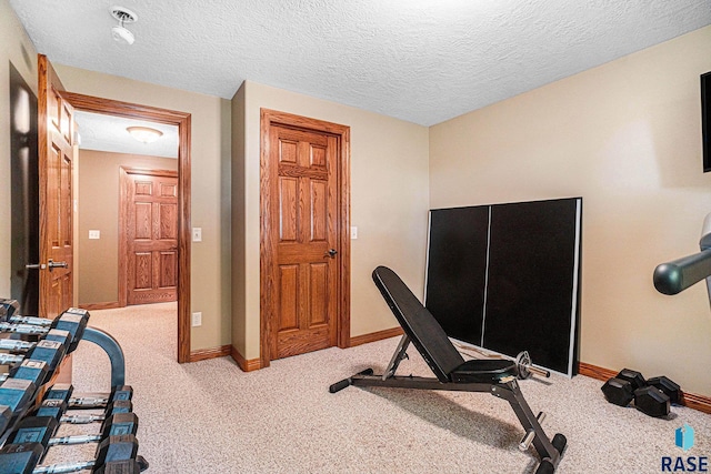 workout room with light carpet and a textured ceiling