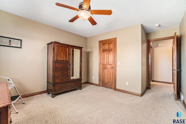 carpeted bedroom with ceiling fan and a textured ceiling