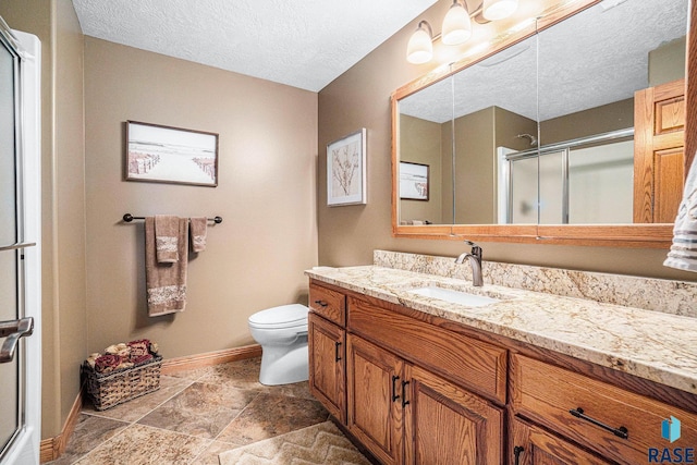 bathroom with walk in shower, vanity, toilet, and a textured ceiling