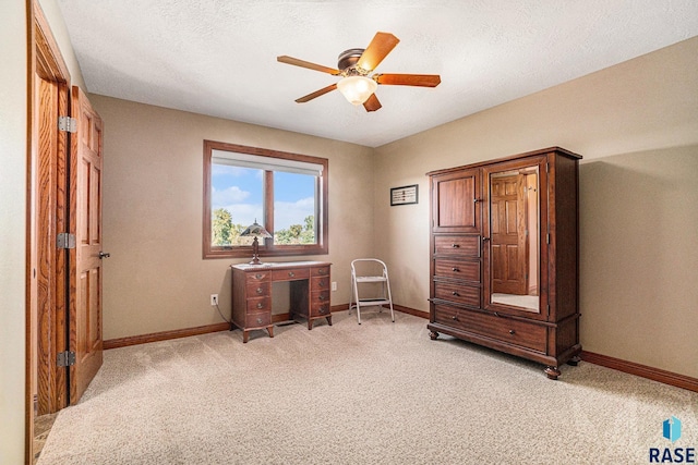 miscellaneous room featuring ceiling fan, light carpet, and a textured ceiling