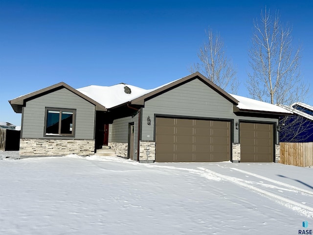 ranch-style house with a garage, stone siding, and fence