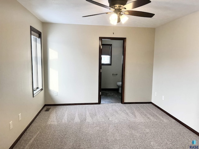 unfurnished room with ceiling fan and carpet